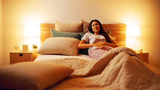 Donna sdraiata a letto che si tiene lo stomaco 
