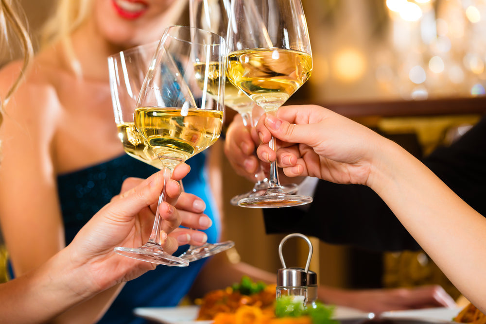 Immagine di diversi amici che bevono un bicchiere di vino bianco