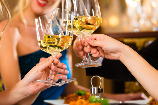 Immagine di diversi amici che bevono un bicchiere di vino bianco