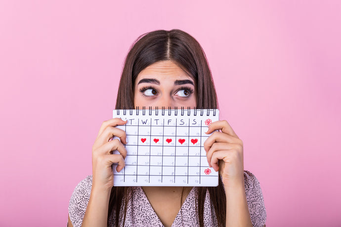 donna che tiene in mano un calendario per il monitoraggio del ciclo mestruale